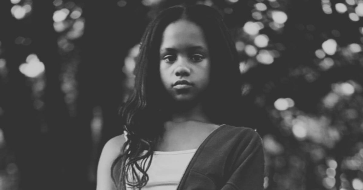 Portrait of a young girl with long hair in a natural outdoor environment.