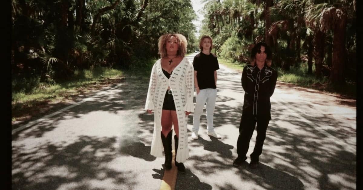 The Sammy Rose Band members standing on a sunlit forest path.