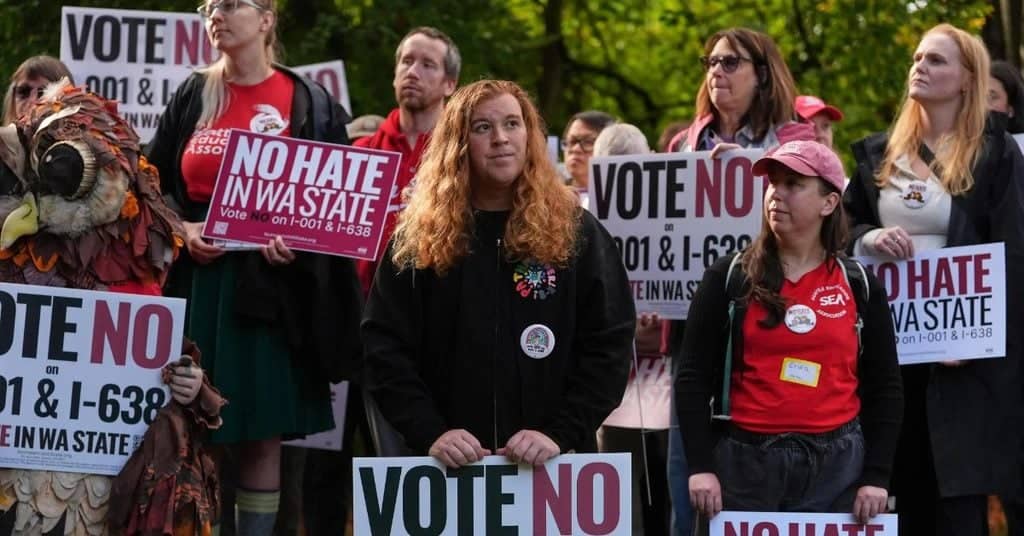 Group of diverse protesters holding signs that read Vote No Hate in WA State.